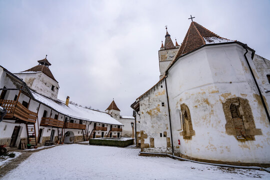 Defensive walls and living accommodations of the fortified Gothic Saxon Church of Saint Nicolas of Harman (Honigberg) in winter, near Brasov, Transylvania, Romania; Brasov, Transylvania, Romania