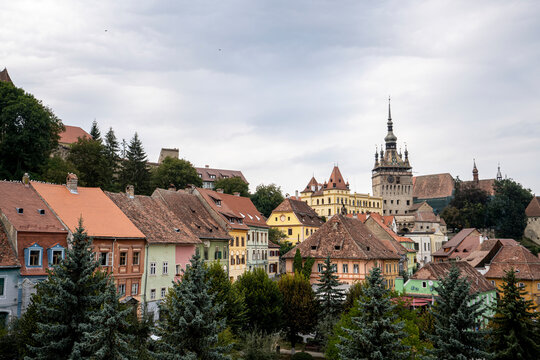 View over rooftops to the clock tower of the Citadel and Old Town of Sighisoara, birth place of Vlad Tepes (Dracula) on an overcast day; Sighisoara, Transylvania, Romania