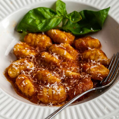 Gnocchi pasta with marinara sauce, garnished with fresh basil and parmesan cheese
.