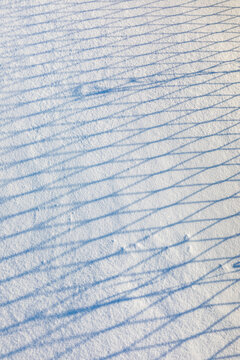 Chain link fence shadow on the snow in winter; Nulato, Interior Alaska, Alaska, United States of America