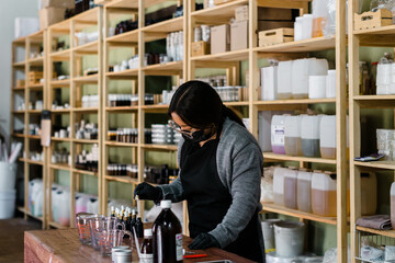 Woman working professionally in the elaboration of soap and natural essences.