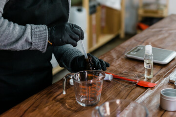Hands of an unrecognizable person in a laboratory making distillation of liquids.