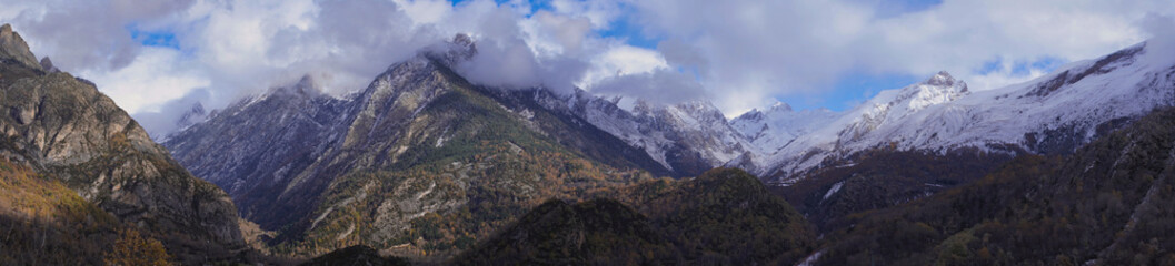 Panor&aacute;mica de unas monta&ntilde;as nevadas en un d&iacute;a nublado de invierno
