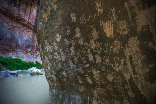 Visitors have left mud handprints on a sandstone wall in Zion Narrows.