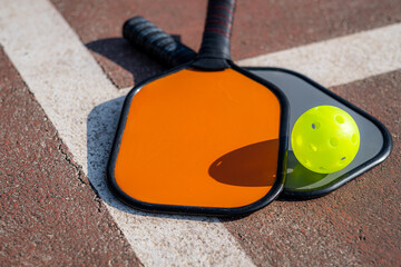 pickleball game, colorful orange and grey pickleball paddle with yellow ball , outdoor sport...