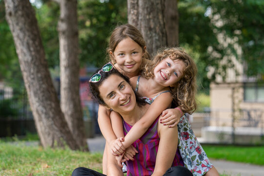 Portrait of a mother with two young daughters in a park; Toronto, Ontario, Canada