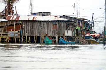 Fototapeta na wymiar Boats moored in front of wooden houses in La Tola, Ecuador