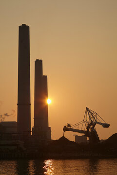 A silhouette of a coal-fired power station at sunset, Lamma Island, Hong Kong.; Yung Shue Wan, Lamma Island, Hong Kong, China.