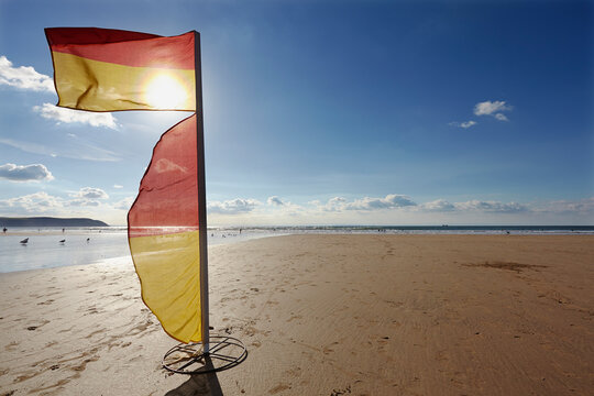 Lifeguard flag on the beach marking the safe area for swimming at Woolacombe Beach in North Devon; Southwest England, Great Britain, United Kingdom
