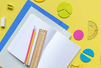 School stationery, fractions, rulers, pencils on yellow background. Back to school, fun education...