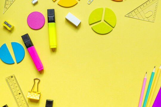 School stationery, fractions, rulers, pencils on yellow background. Back to school, fun education concept. Set of supplies for mathematics and for school. Close up