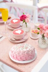 Beautiful scene with coffee cups, pink roses, orange juice and pink cake