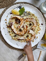 A plate with seafood with a baby hand
