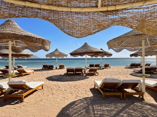 Beach with chaise longue and sand.