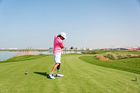 Amputee with leg prosthesis driving the ball on the golf course; Okotoks, Alberta, Canada