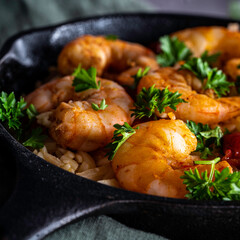 Shrimp scampi with pasta (orzo) garnished with parsley and grape tomatoes