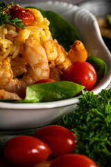 Shrimp scampi with pasta (orzo) garnished with parsley and grape tomatoes