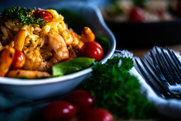 Shrimp scampi with pasta (orzo) garnished with parsley and grape tomatoes