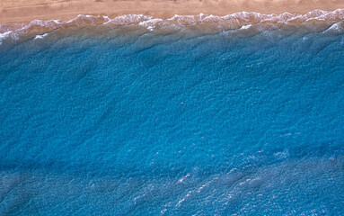 Concept summer sunny travel image. Turquoise water wave with sand beach background from aerial top view