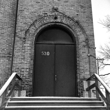 Brick building with arched entry over double doors and wooden steps; Winnipeg, Manitoba, Canada