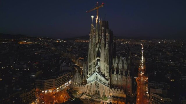 Evening flying clockwise around Sagrada Familia Cathedral in Barcelona