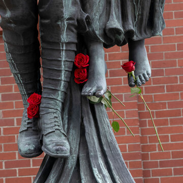 'Angel of Victory' bronze sculpture, a historic war memorial with fresh red roses placed on the feet of the sculpture; Vancouver, British Columbia, Canada