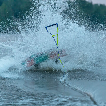 Wakeboard and rope rise in the spray from a lake after a wakeboarder takes a fall, Lake of the Woods, Ontario; Kenora, Ontario, Canada