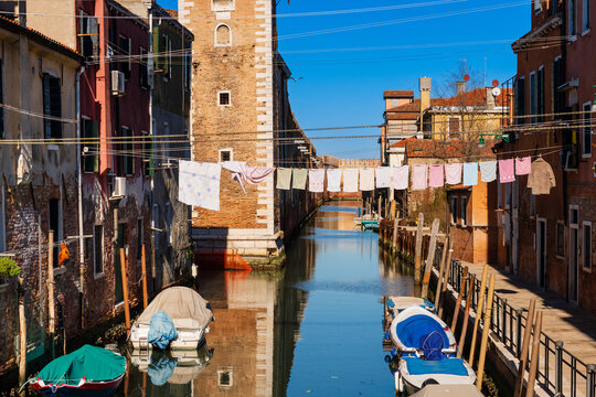 Drying laundry on a clothesline over the Rio della Tana canal in Castello District, Venice; Venice, Veneto, Italy