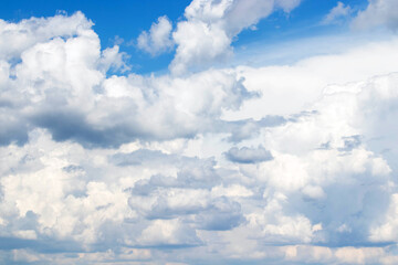 White cumulus clouds in the blue sky, illuminated by the bright spring sun.