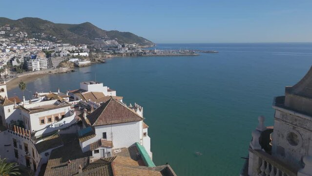view of coastal town of Sitges Spain flying backwards revealing castle