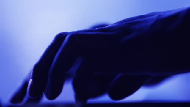 Hands typing on a keyboard with a blue hue