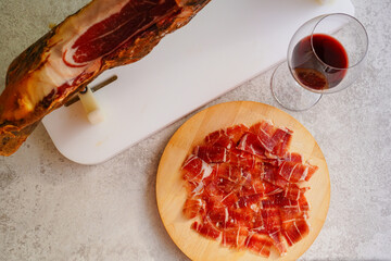 Sliced of Spanish Jamón iberico and red wine glass
