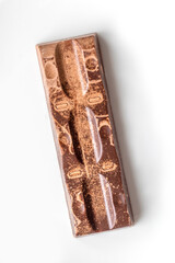 Expired chocolate. Violations in shelf life of products. Bloomed chocolate. An expired chocolate bar is lying on white backdrop. Chocolate has significant discoloration