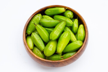 Bilimbi fruit in bamboo basket on white background.