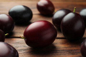 Tasty ripe plums on wooden table, closeup