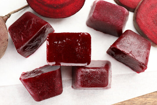 Frozen beetroot puree cube and fresh beetroot on white background, top view