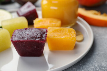 Frozen beet, pumpkin and zucchini puree cubes on plate, closeup