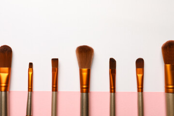 Set of makeup brushes on color background, flat lay. Space for text