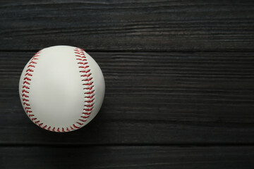 Baseball ball on black wooden table, top view with space for text. Sports game