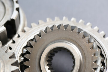Many different stainless steel gears on grey background, closeup