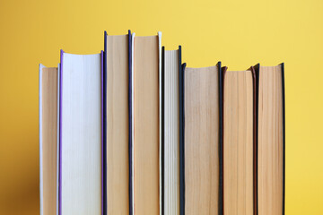 Collection of hardcover books on yellow background