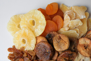 Pile of different dried fruits on white background, top view