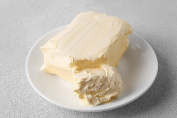 Plate with tasty homemade butter on white textured table