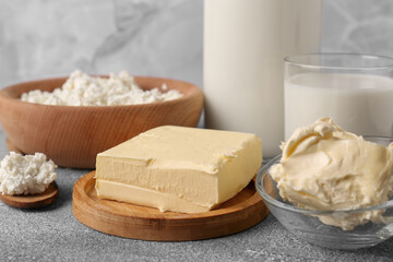 Piece of tasty homemade butter and dairy products on grey table
