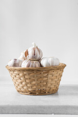Garlic bulbs in a woven basket, garlic in woven wood basket, raw garlic, Allium sativum