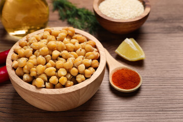 Delicious chickpeas and different products on wooden table, space for text. Hummus ingredients