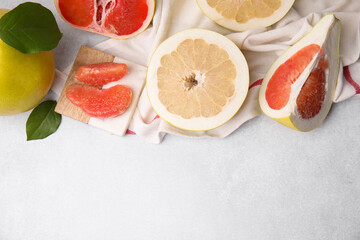 Different sorts of tasty pomelo fruits on white textured table, flat lay. Space for text