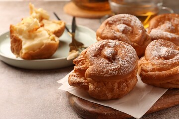 Delicious profiteroles filled with cream on grey table
