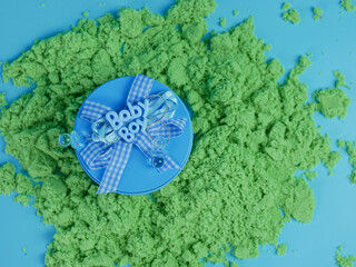 blue gift for baby boy on green sand