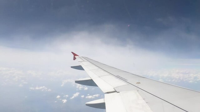 Airliner Wing Between Two Layers Of Clouds Fly in the Blue Sky - Timelapse